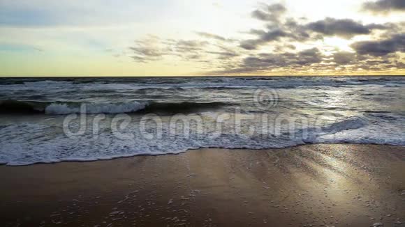 傍晚海浪在沙滩上翻滚慢潮视频的预览图