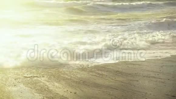 太阳照亮了沙滩上的海浪视频的预览图