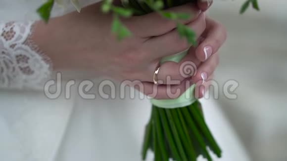 新娘手里的婚礼花束不错剪辑未婚妻穿着一件漂亮的白色连衣裙捧着一束美丽的婚礼花视频的预览图