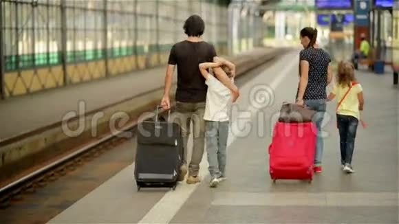 幸福的家庭和小女孩和男孩一起去火车站爸爸妈妈和孩子们一起穿过机场视频的预览图