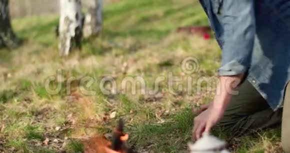 男人点着火的地方吹真正的朋友人们户外露营帐篷度假在秋天的旅行秋天的晴天视频的预览图