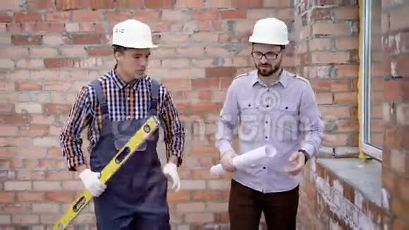 穿长袍戴建筑头盔和建筑水平的年轻男性建筑工人视频的预览图