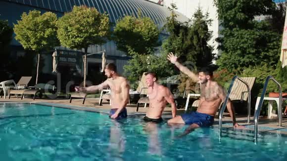 三个穿着粉红色泳衣的男人和年轻女人在游泳池里竖起大拇指视频的预览图