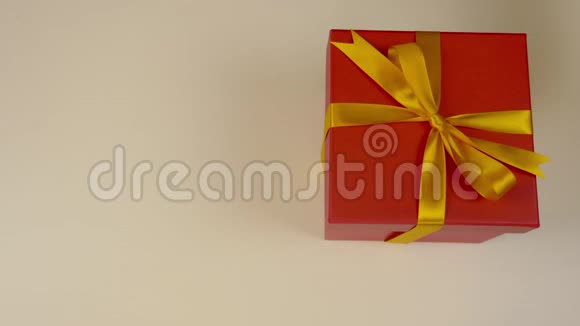 大的未包装红色礼品盒与黄金丝带双手解开红色礼盒上的金色丝带高层景观视频的预览图