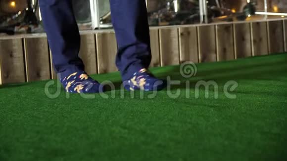 男人踩着绿色的门垫男人穿着袜子绿色地毯上视频的预览图