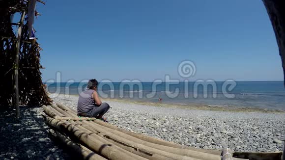 胖男孩坐在开阔的大海上凝视着视频的预览图