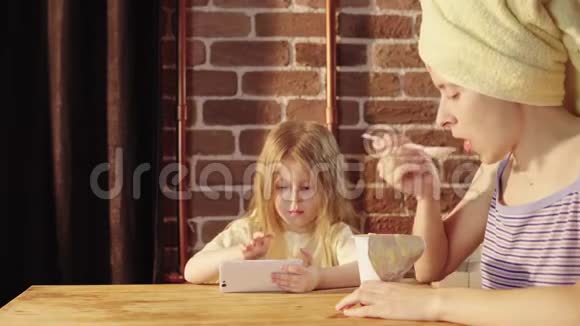 一个年轻的女人和一个小女孩在早餐时吃酸奶视频的预览图