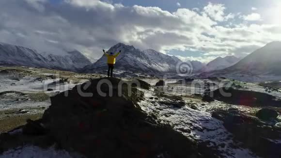 登山男登山者用冰锥在雪山顶举手视频的预览图