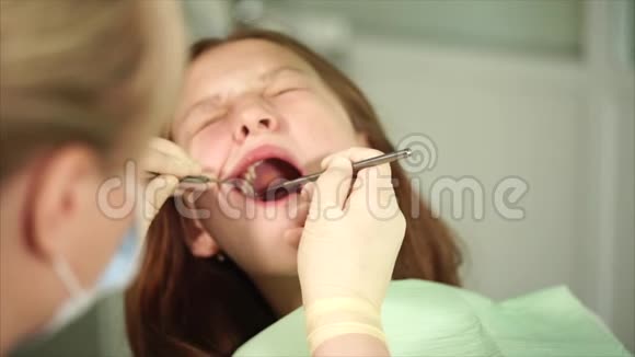 牙齿矫正器检查一名来诊所治疗的青少年的牙齿视频的预览图