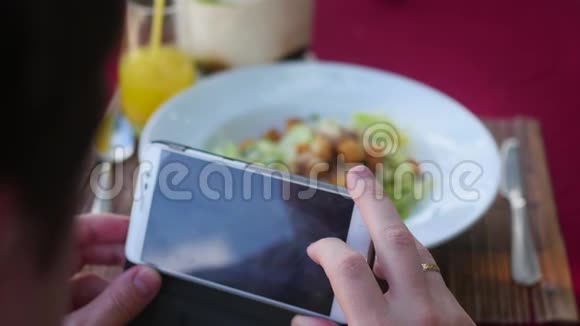 这家伙拍了一盘食物的照片用手机相机在餐厅用餐拍照视频的预览图