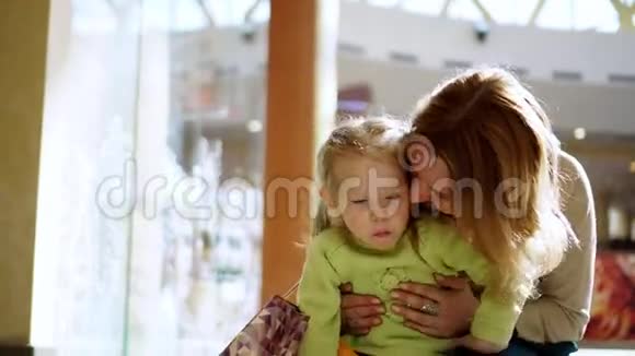 小女孩的母亲亲吻女儿的脸颊视频的预览图