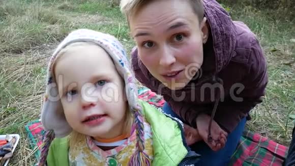 妈妈和女儿去野餐我女儿吃东西在镜头里做鬼脸视频的预览图