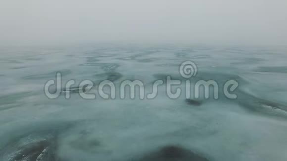 飞越冰冻的海上海岸线在雾蒙蒙的寒冷的冬日出现冰裂缝视频的预览图
