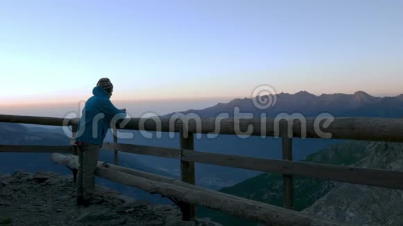 从木阳台看日出的人在阿尔卑斯山的高处喝杯热饮料视频的预览图