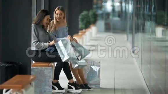 两个年轻的女人互相分享新买的东西视频的预览图