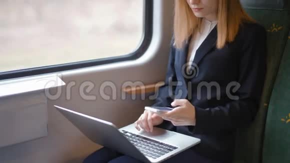 年轻的商务女性正在电脑上工作在火车上打电话发短信视频的预览图
