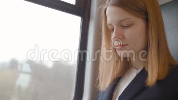 不错的商务女士坐在火车的窗边在笔记本电脑上打字视频的预览图