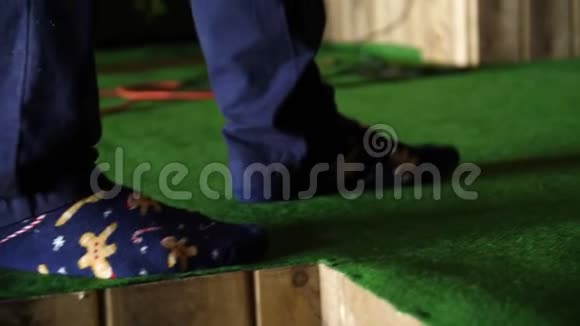 男人踩着绿色的门垫男人穿着袜子绿色地毯上视频的预览图
