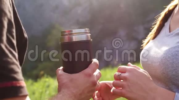 游客们在山上喝一杯热水瓶里的茶视频的预览图