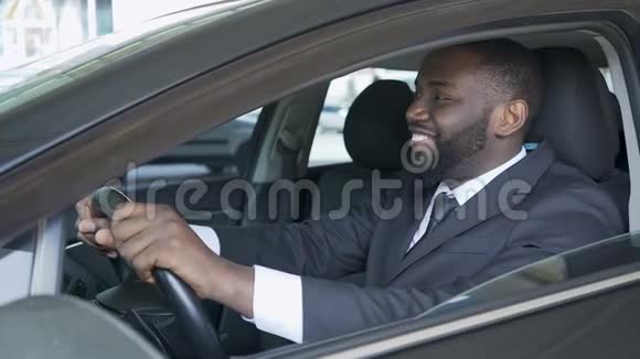 美国黑人男子坐在昂贵的汽车上满意而微笑试驾视频的预览图