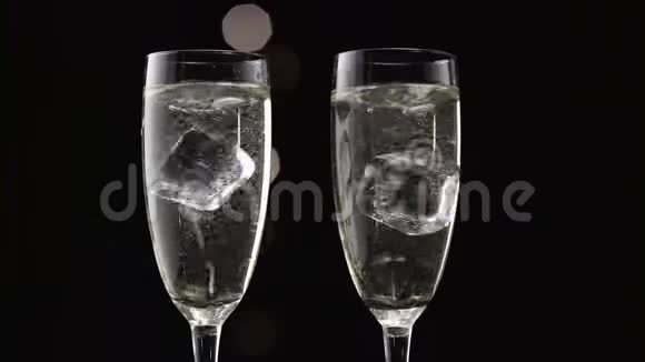 两杯装满了冰块的香槟波克闪烁的黑色背景关门视频的预览图