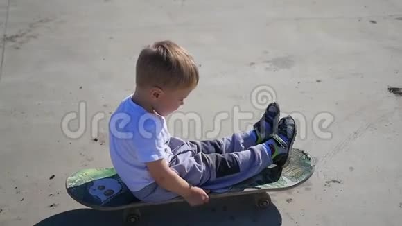 骑在滑板上的小孩子户外运动视频的预览图
