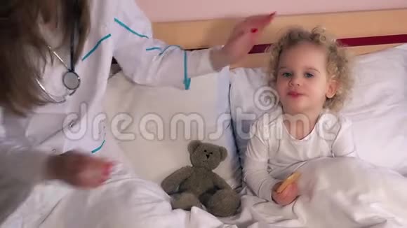 小女孩在床上做健康检查儿科医生检查头部和喉咙视频的预览图