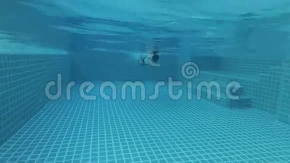 活泼的年轻人在游泳池游泳爬行风格水下景观假期操作摄像机视频的预览图