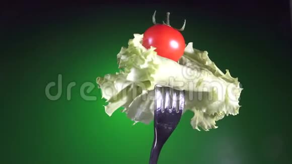 用红鲜番茄和生菜叉旋转绿色背景视频的预览图