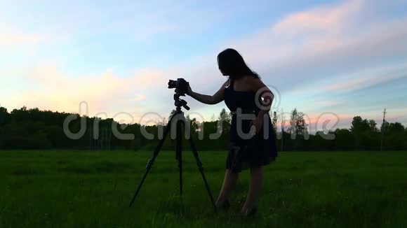 一个年轻的女人用DSRL相机拍摄大自然总体计划视频的预览图