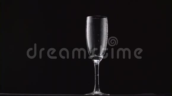 香槟被倒入薄柄上的薄雾玻璃中黑色背景视频的预览图