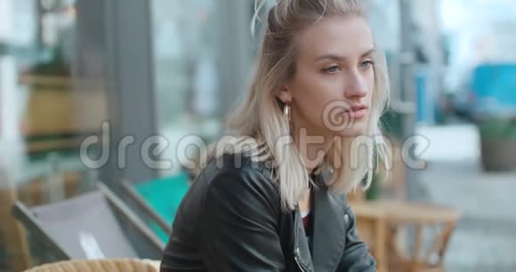 可怜的白种人女孩坐在户外咖啡馆等人视频的预览图