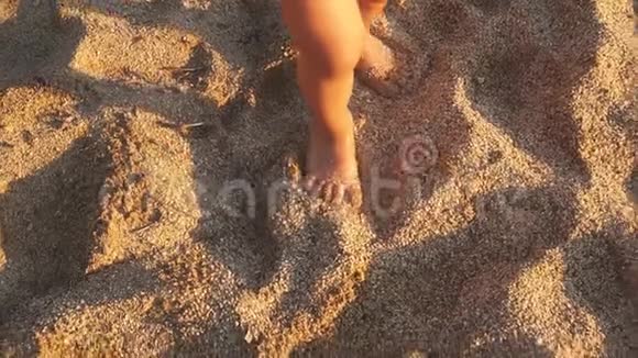 在沙滩上散步的小宝宝腿的特写视频的预览图