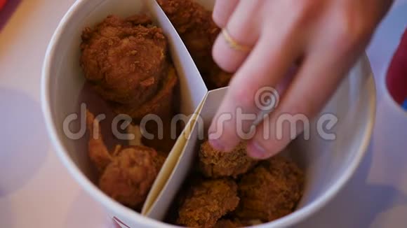 特写手拿一块炸鸡放在盘子上快餐店视频的预览图