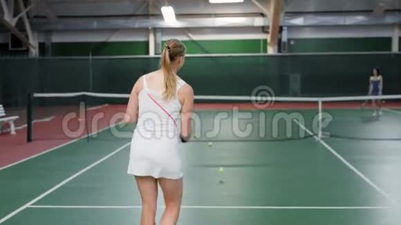 成年女子网球赛结束一名身穿白色运动服的女子赢得比赛运动员们拥抱和摇动视频的预览图
