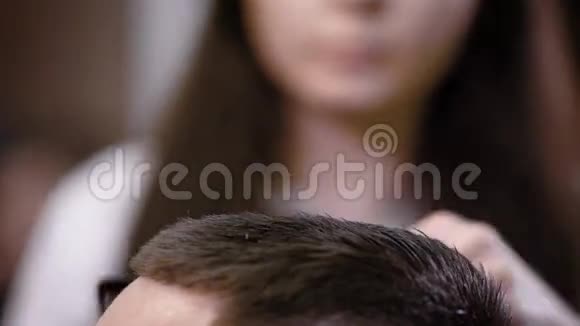 无法辨认的理发师女士用剪刀剪头发给顾客视频的预览图