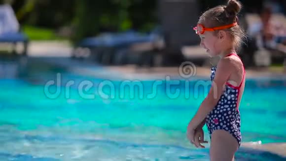 小男孩向游泳池里可爱的小女孩喷水视频的预览图