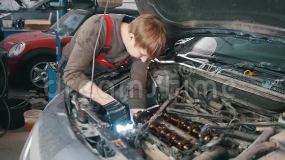机修工带灯修理汽车发动机汽车修理在车间工作视频的预览图