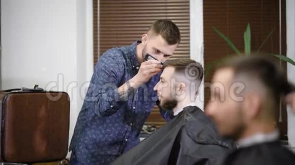集中理发师使用修剪同时在理发店为客户做时尚发型视频的预览图