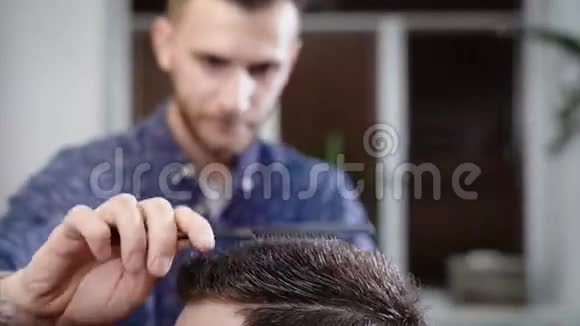 在理发店里梳头用梳子和梳子做时髦造型的人的头部特写镜头视频的预览图