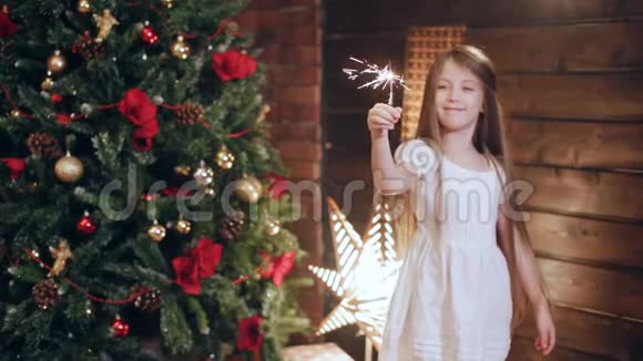 一个小女孩在圣诞树附近燃烧着火花视频的预览图