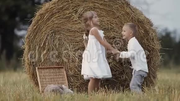 两个幼儿在田里跳得很开心男孩和女孩吃水果日落视频的预览图