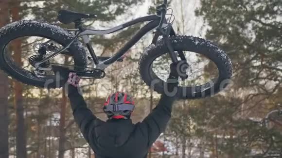 专业的极限运动员骑自行车在户外骑胖自行车上山骑自行车的人走在冬天的雪林里男子视频的预览图