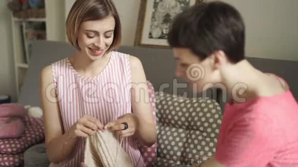 两个女朋友在看针织纱女人休闲编织视频的预览图
