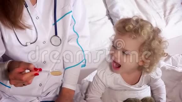 医生给孩子用勺子剂量的药水喝糖浆视频的预览图