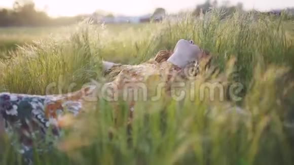 美丽的嬉皮士女人在日落时带着绿草中的可怕的怪物在户外玩得很开心视频的预览图