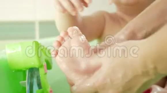 这位母亲洗了足有吸引力的婴儿肥皂男孩在微笑玩着五颜六色的玩具和水孩子为了视频的预览图