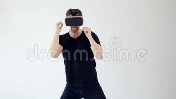 一个男人戴着虚拟现实耳机做着动作就像和某人打架一样白色背景4K视频的预览图