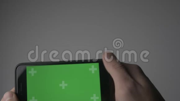 在水平位置用绿色屏幕色键关闭持智能手机触摸视频的预览图