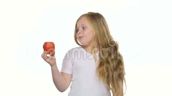 小女孩咬苹果竖起大拇指白色背景视频的预览图